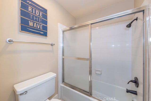 full bath featuring toilet and combined bath / shower with glass door