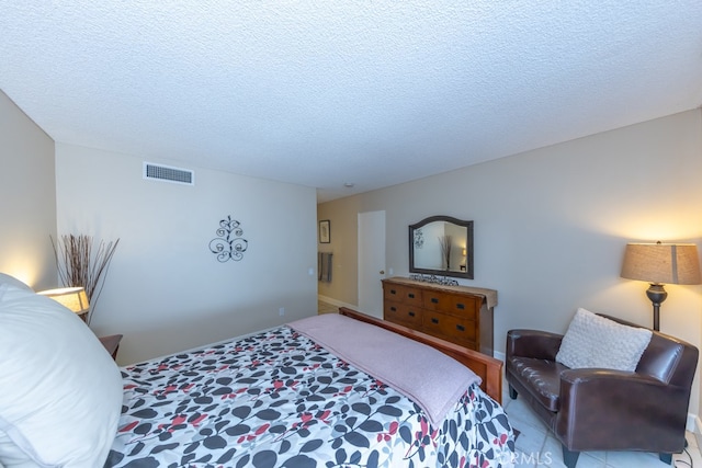 bedroom with a textured ceiling and visible vents