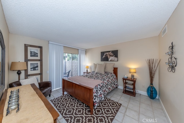 bedroom featuring access to exterior, light tile patterned floors, visible vents, a textured ceiling, and baseboards