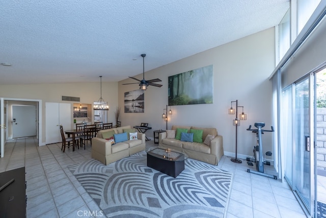 living area featuring a textured ceiling, high vaulted ceiling, light tile patterned flooring, and visible vents