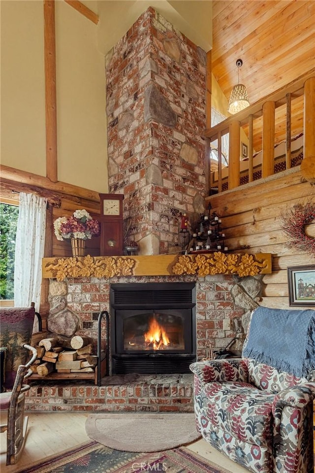 interior space featuring hardwood / wood-style flooring, a fireplace, rustic walls, and high vaulted ceiling