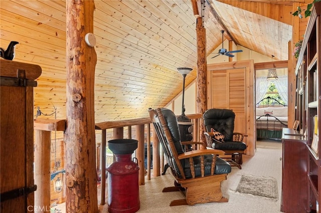 sitting room with vaulted ceiling, wood walls, light colored carpet, ceiling fan, and wooden ceiling