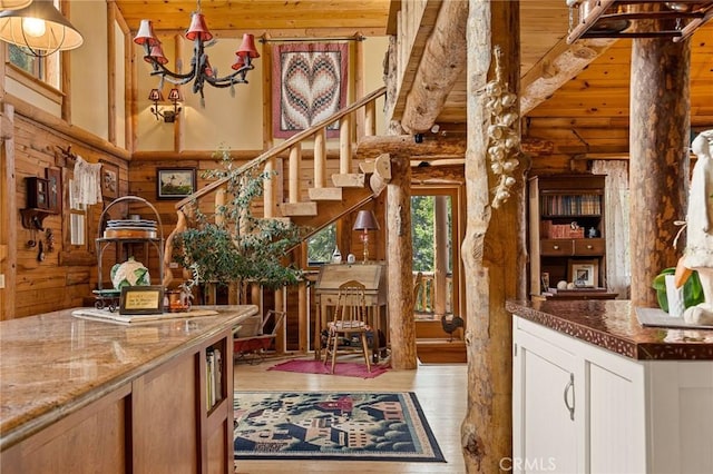 interior space with high vaulted ceiling, beamed ceiling, rustic walls, light hardwood / wood-style floors, and wooden ceiling