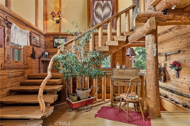 stairs featuring hardwood / wood-style flooring, a high ceiling, and wood walls