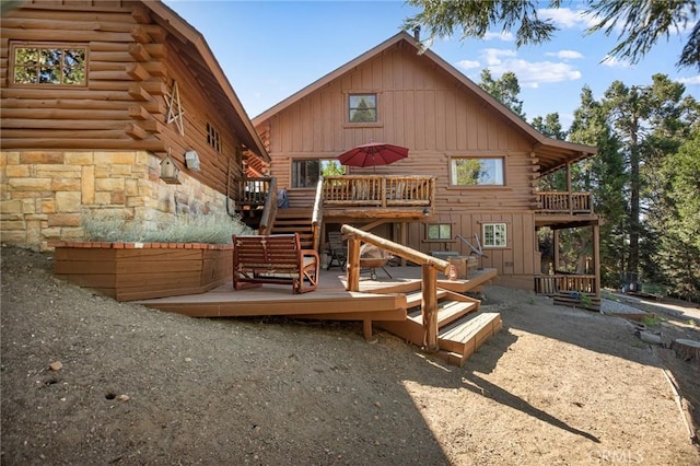 rear view of property featuring a wooden deck