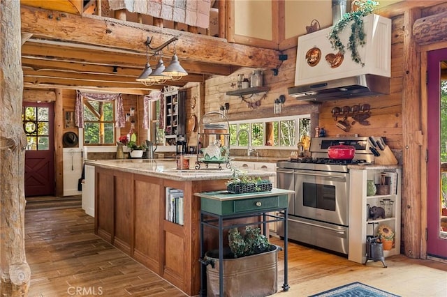 kitchen with pendant lighting, light stone counters, stainless steel gas range oven, and light hardwood / wood-style floors