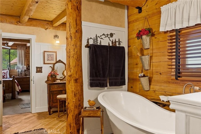 bathroom featuring wood walls, a bath, beam ceiling, and wooden ceiling