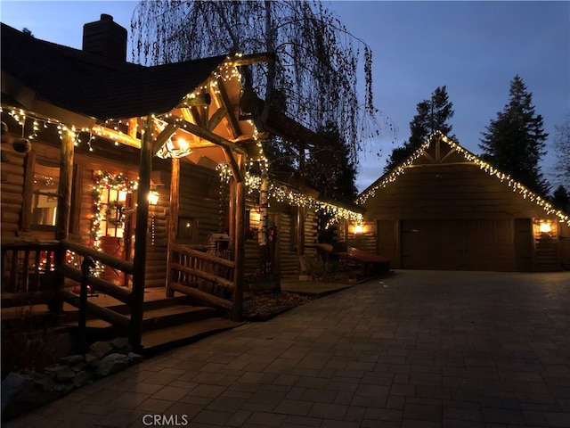 patio terrace at dusk featuring a garage