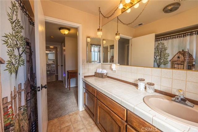 bathroom featuring tile patterned flooring, vanity, and decorative backsplash