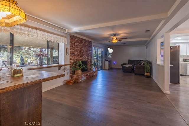 unfurnished living room with ceiling fan, a fireplace, and dark hardwood / wood-style floors