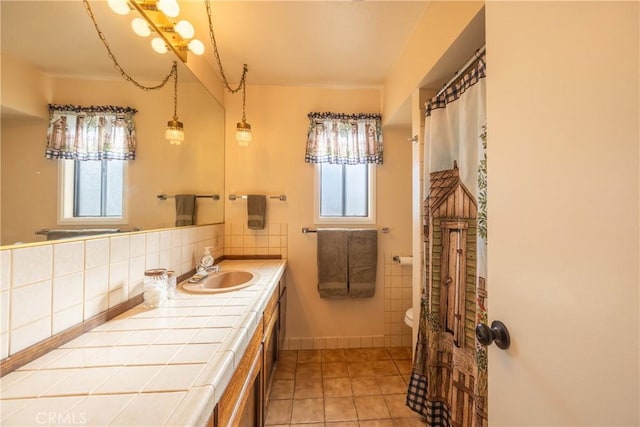 bathroom with toilet, vanity, decorative backsplash, and tile patterned floors