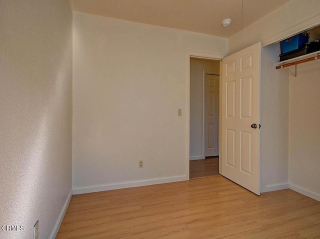 unfurnished bedroom with a closet and light wood-type flooring