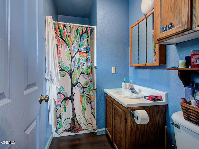 bathroom featuring vanity, hardwood / wood-style flooring, and toilet