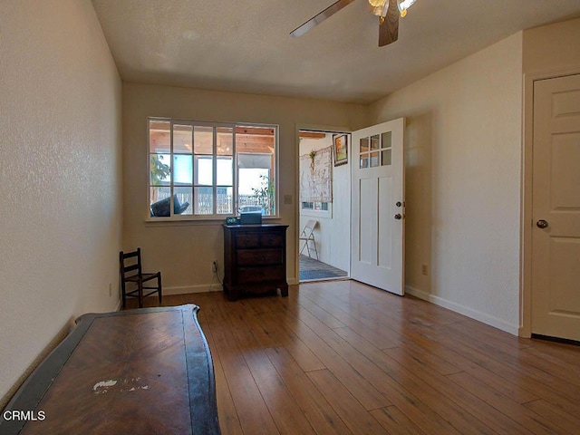 interior space featuring wood-type flooring and ceiling fan