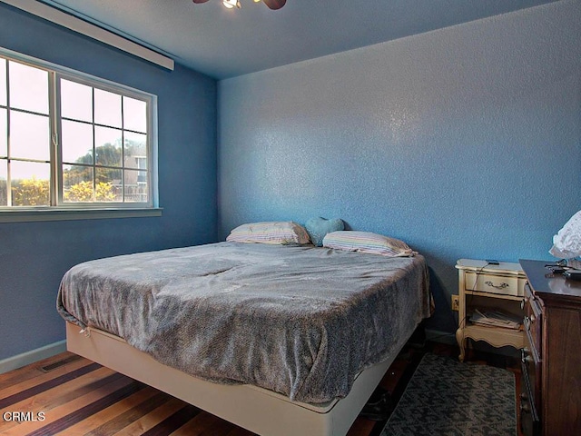 bedroom featuring ceiling fan and dark hardwood / wood-style floors