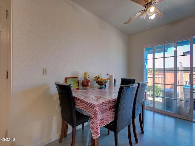 dining room with a ceiling fan and baseboards