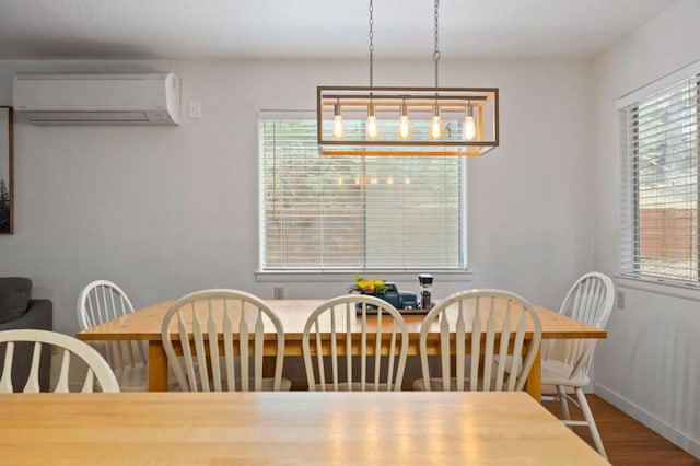 dining space featuring wood-type flooring, a notable chandelier, plenty of natural light, and a wall mounted air conditioner