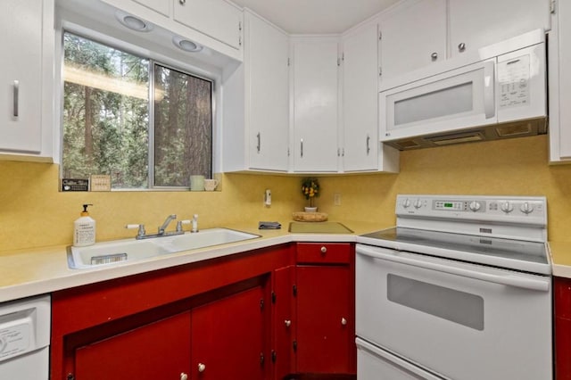 kitchen with sink, white appliances, and white cabinetry