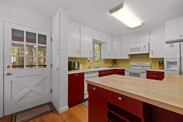 kitchen featuring light hardwood / wood-style flooring, white appliances, butcher block counters, and plenty of natural light