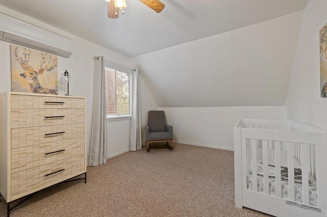 bedroom with lofted ceiling, ceiling fan, a crib, and carpet flooring