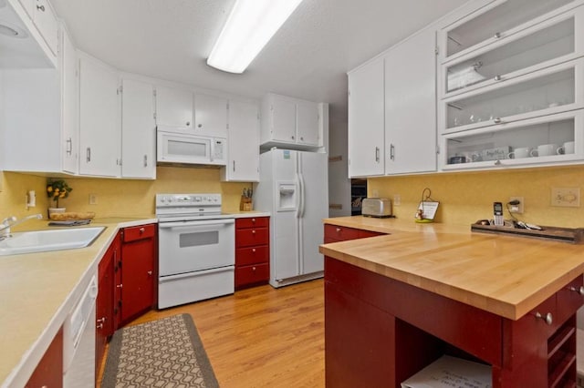 kitchen featuring light wood-type flooring, white appliances, white cabinetry, and sink