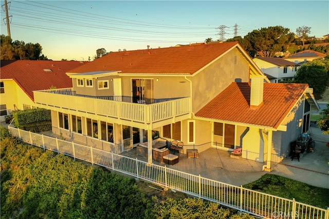 rear view of property with a balcony and a patio