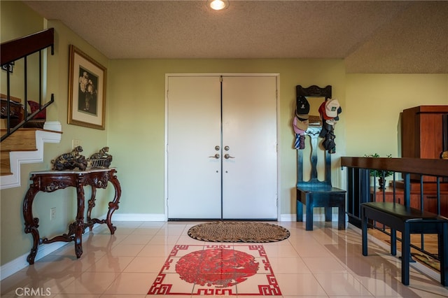 tiled foyer with a textured ceiling