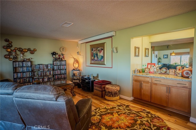 living room featuring a textured ceiling and light hardwood / wood-style floors