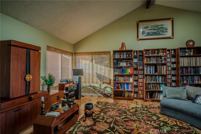 interior space featuring vaulted ceiling with beams, a textured ceiling, and hardwood / wood-style floors