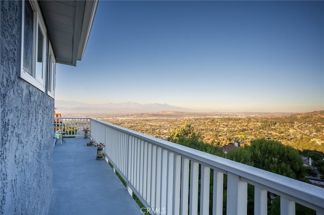 balcony at dusk featuring a mountain view