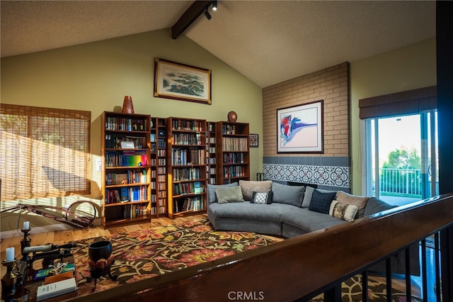 living room with a textured ceiling and vaulted ceiling with beams