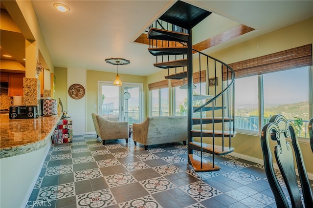 interior space with dark tile patterned floors, french doors, and plenty of natural light