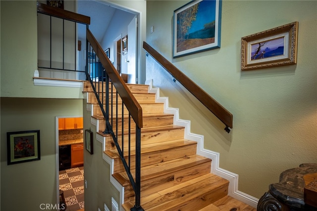 stairs featuring vaulted ceiling and hardwood / wood-style flooring