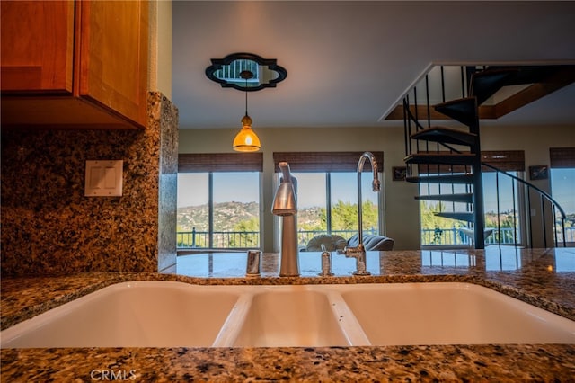 kitchen with dark stone counters, a mountain view, and plenty of natural light