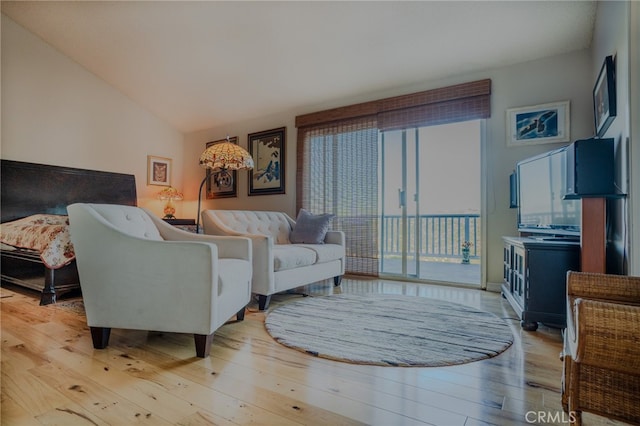 living room with light hardwood / wood-style flooring and vaulted ceiling