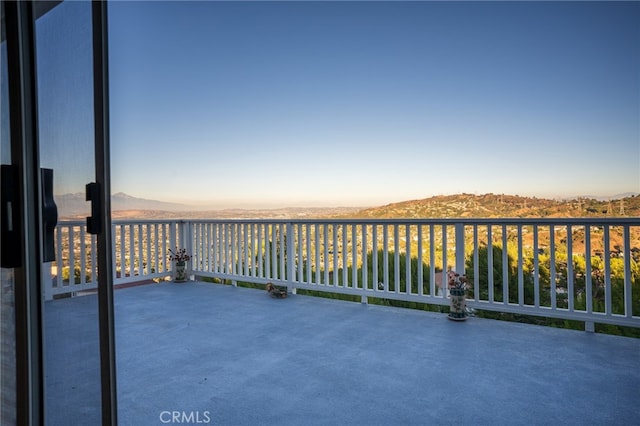 balcony at dusk featuring a mountain view