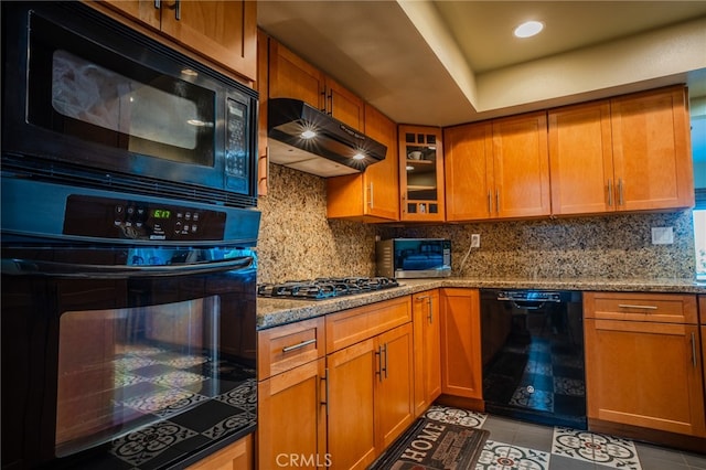 kitchen with light stone counters, light tile patterned floors, decorative backsplash, and black appliances