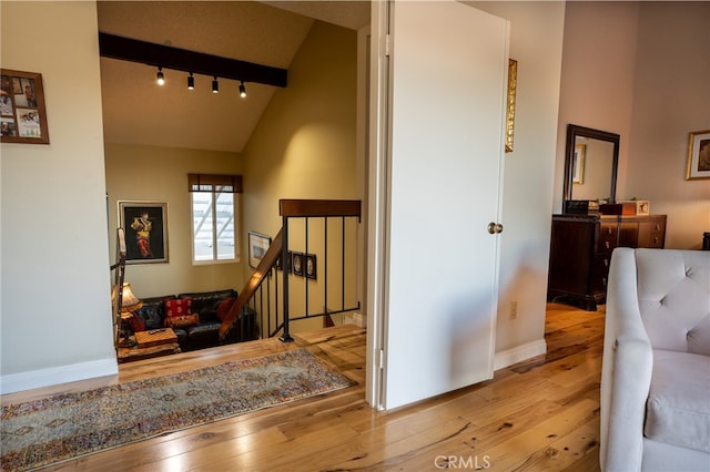 interior space with lofted ceiling with beams and hardwood / wood-style floors