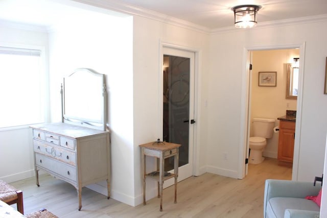 bedroom with ensuite bathroom, crown molding, and light hardwood / wood-style flooring