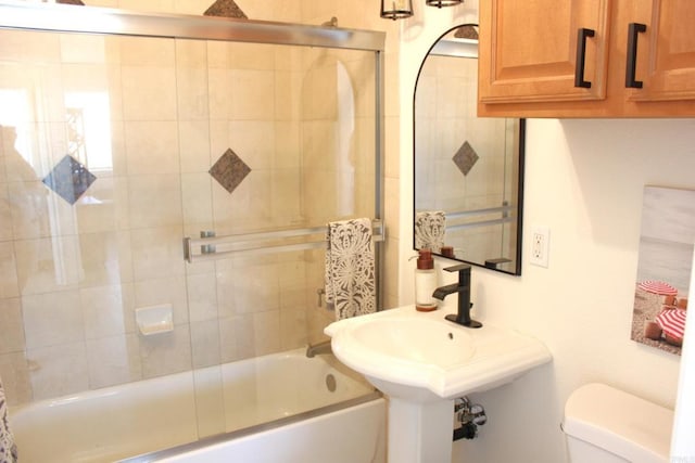 bathroom featuring shower / bath combination with glass door and toilet