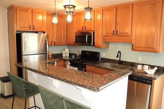 1365 Seacoast Dr Unit E, Imperial Beach, CA 91932 - kitchen with stainless steel appliances, a sink, decorative backsplash, a kitchen bar, and dark stone countertops