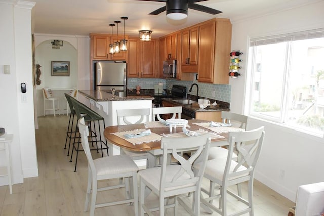 1365 Seacoast Dr Unit E, Imperial Beach, CA 91932 - kitchen with appliances with stainless steel finishes, decorative backsplash, light wood-style flooring, healthy amount of natural light, and ornamental molding