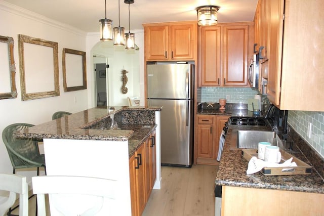 1365 Seacoast Dr Unit E, Imperial Beach, CA 91932 - kitchen featuring appliances with stainless steel finishes, a center island, ornamental molding, dark stone counters, and light wood-style floors