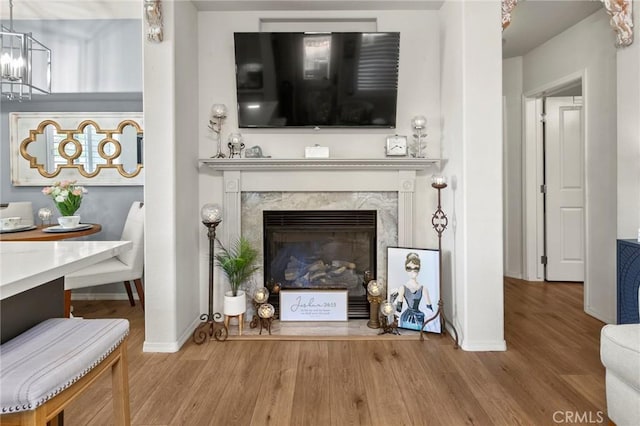 interior space with hardwood / wood-style floors, a high end fireplace, and a chandelier