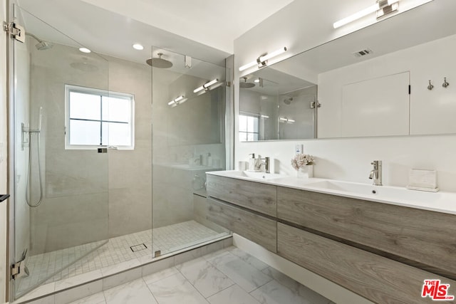 bathroom featuring vanity and a shower with shower door