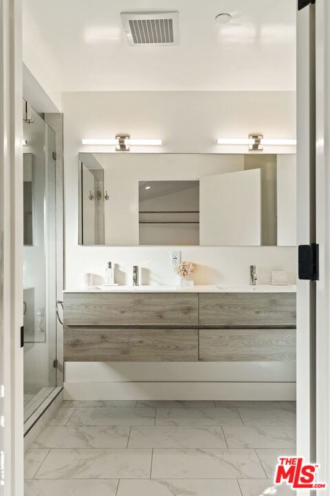 bathroom with vanity and a shower with shower door