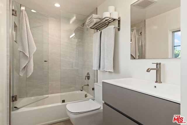 full bathroom with shower / bath combination with glass door, vanity, and toilet