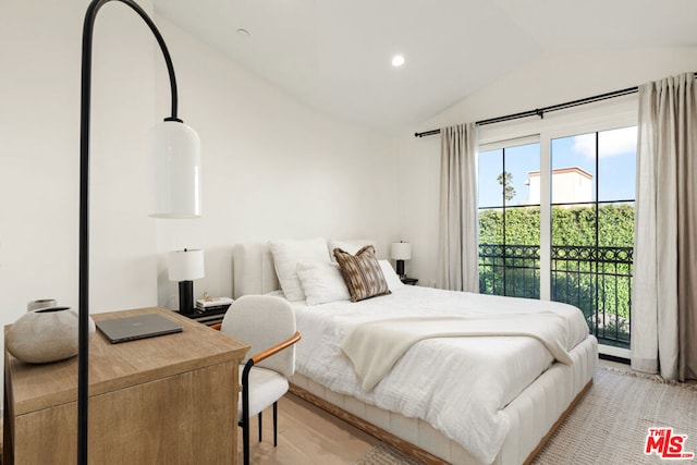 bedroom with lofted ceiling and access to exterior