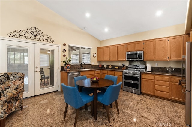 kitchen with stainless steel appliances, granite finish floor, a sink, french doors, and dark countertops