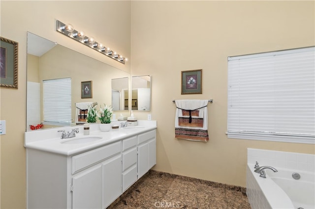 full bath with a garden tub, double vanity, and a sink